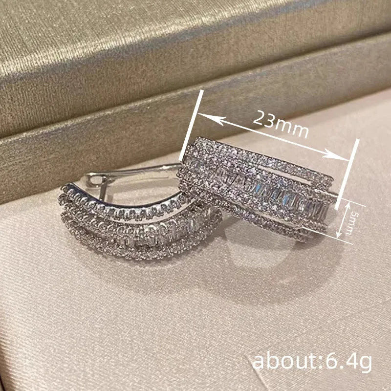 A pair of women's geometric stud earrings with inlaid zircon detail in a white gold colour.