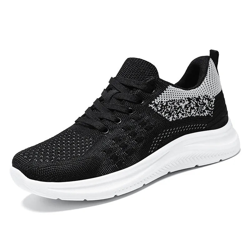 Women's low-top black mesh sneakers with a round toe and white PVC sole on a plain background.