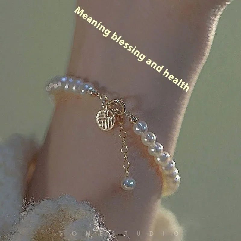 A Chinese style glass bracelet with bamboo leaf and bead designs on a wrist.