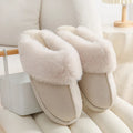 A pair of plush fur-lined indoor slippers with a round toe and a flat PVC sole.