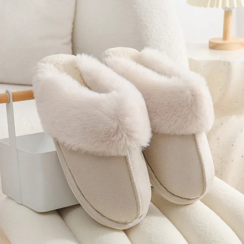 A pair of plush fur-lined indoor slippers with a round toe and a flat PVC sole.