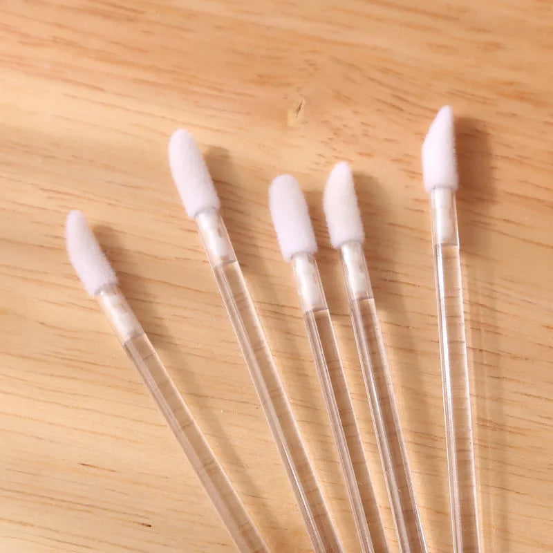 Disposable lip brushes with black handles and flocked tips in bulk packaging for lipstick and gloss application