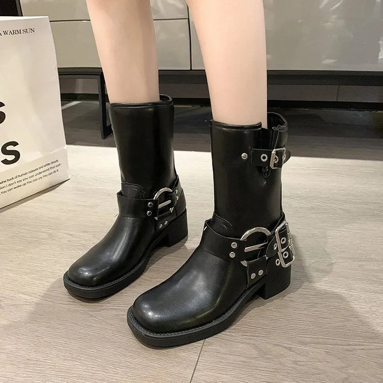 Women's black leather platform boots with belt buckle detail at mid-calf height