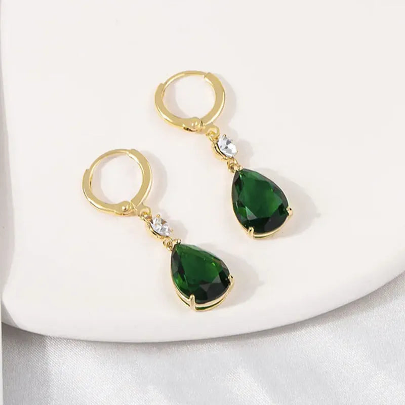 A pair of green geometric teardrop alloy earrings on a plain background.