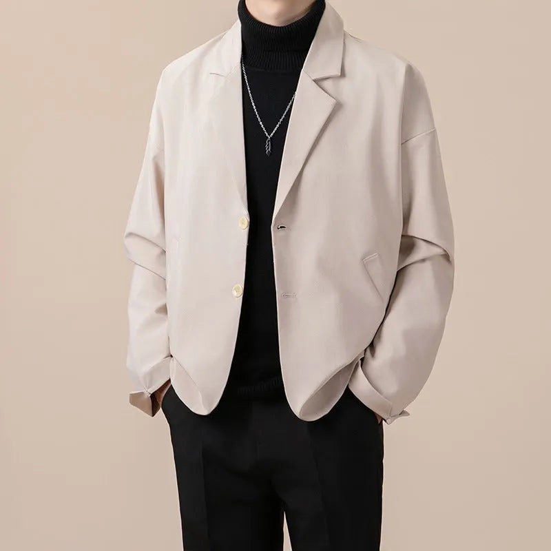 Man wearing a loose-fit apricot coloured casual suit jacket with long sleeves.