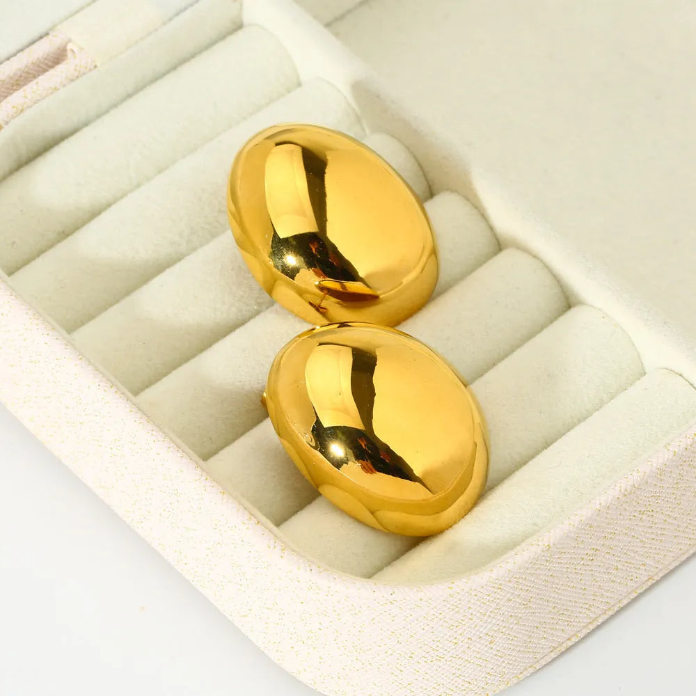 A pair of geometric stainless steel ear studs with a linear design and a glazed gold-coloured surface.