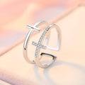 Adjustable open ring showing double cross design with zircon stones and sterling silver inlay on copper.