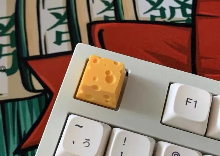 Close-up of a yellow solid resin cheese-themed keycap for mechanical keyboards.