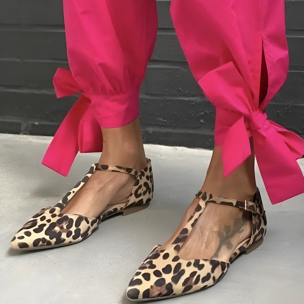 Leopard print women's pumps with pointed toe and chunky low heel featuring cross shoulder strap