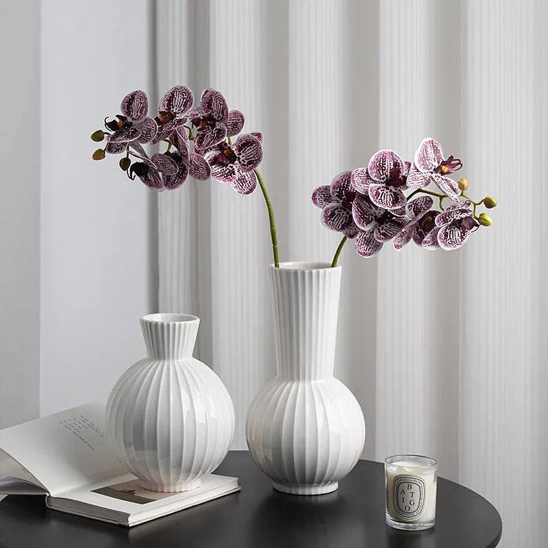 White ceramic ball-shaped vase with striped American country design on a table.