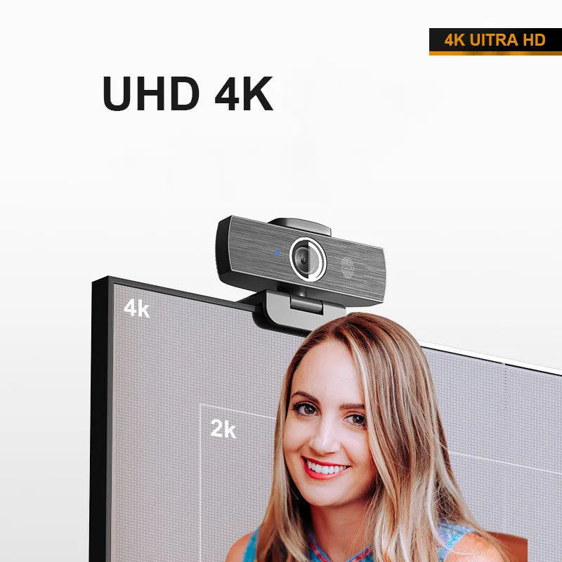 Black USB computer webcam with attached cable and magnetic privacy cover on a desk