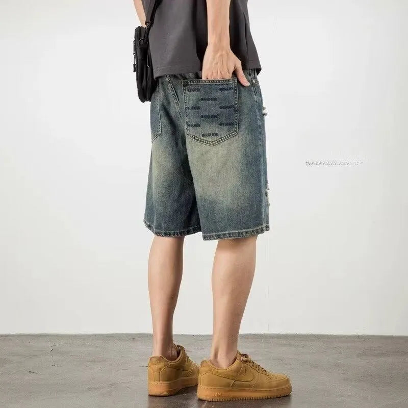 Retro blue denim men's shorts with distressed holes and straight leg cut on mannequin