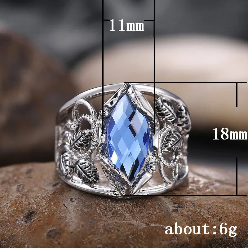 Women's horse eye shaped blue crystal alloy ring on a finger, showing geometric design.