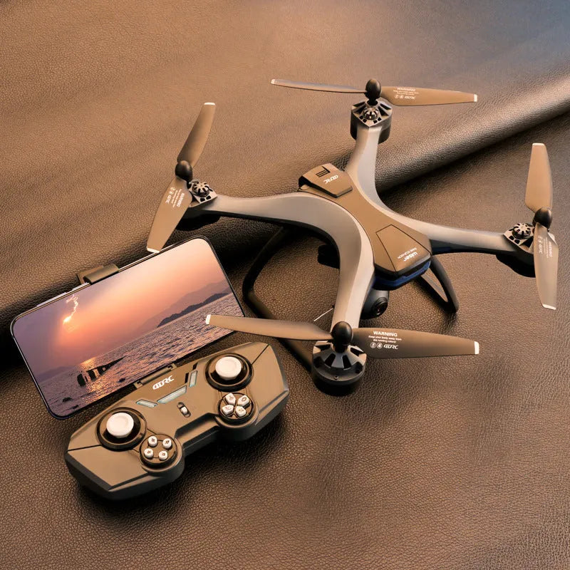 GPS remote control quadrocopter drone with camera on landing gear, next to its handle-style transmitter.