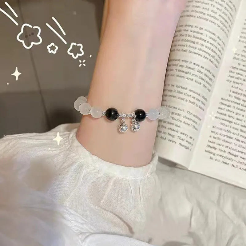 A Chinese style glass bracelet with bamboo leaf and bead designs on a wrist.