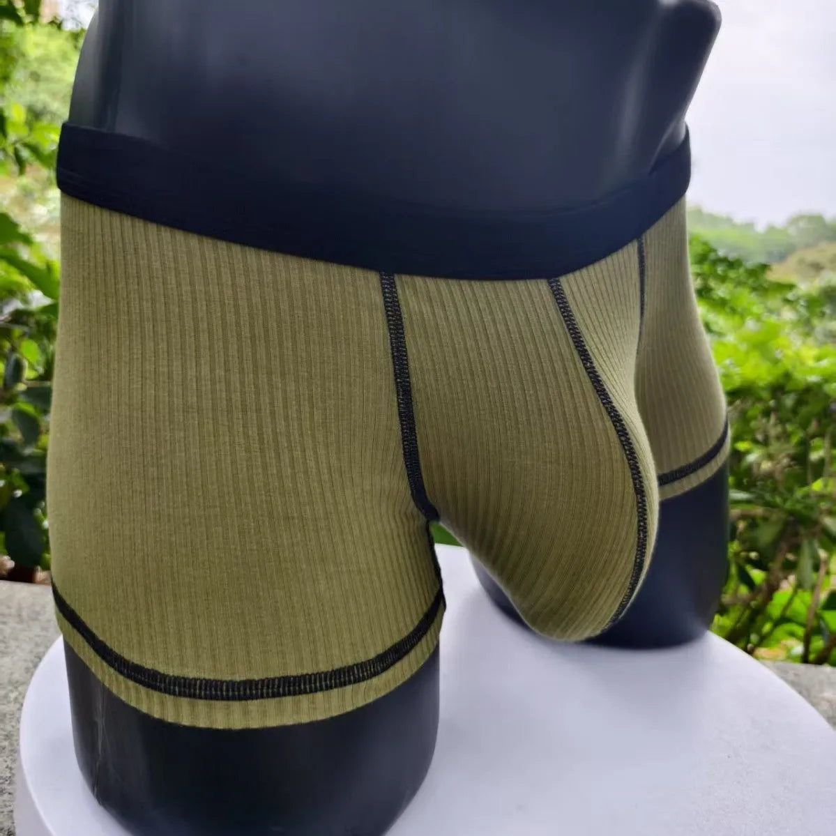Men's solid-colour fibre boxer shorts on a white background showing hip-lifting design.