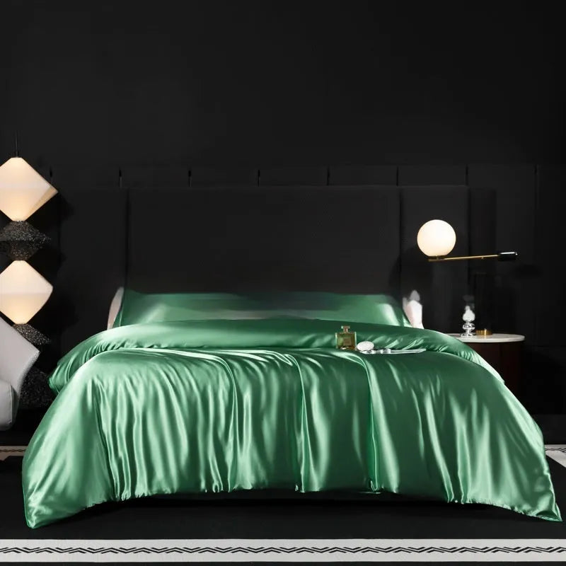 Silk four-piece bed sheet set in a solid colour on a bed, showing duvet cover and pillowcases.