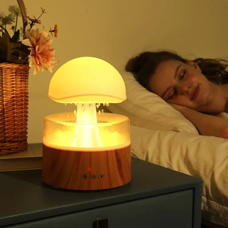 White Rain Cloud Humidifier showing raindrop effect, colour-changing light, and remote control on a table.