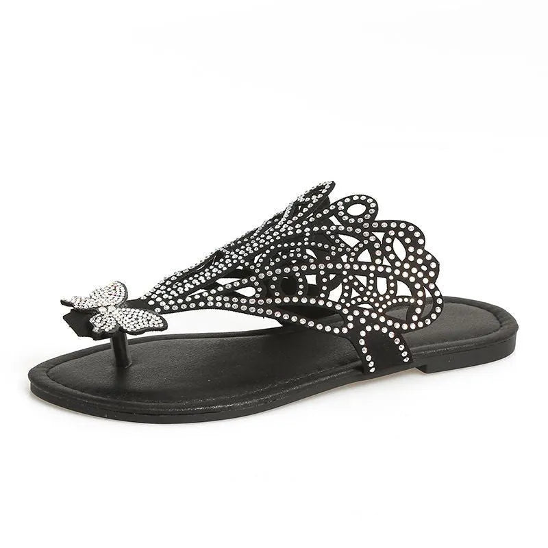 Women's black slip-on sandals with rhinestone detail on flip-toe hollow design and flat rubber sole