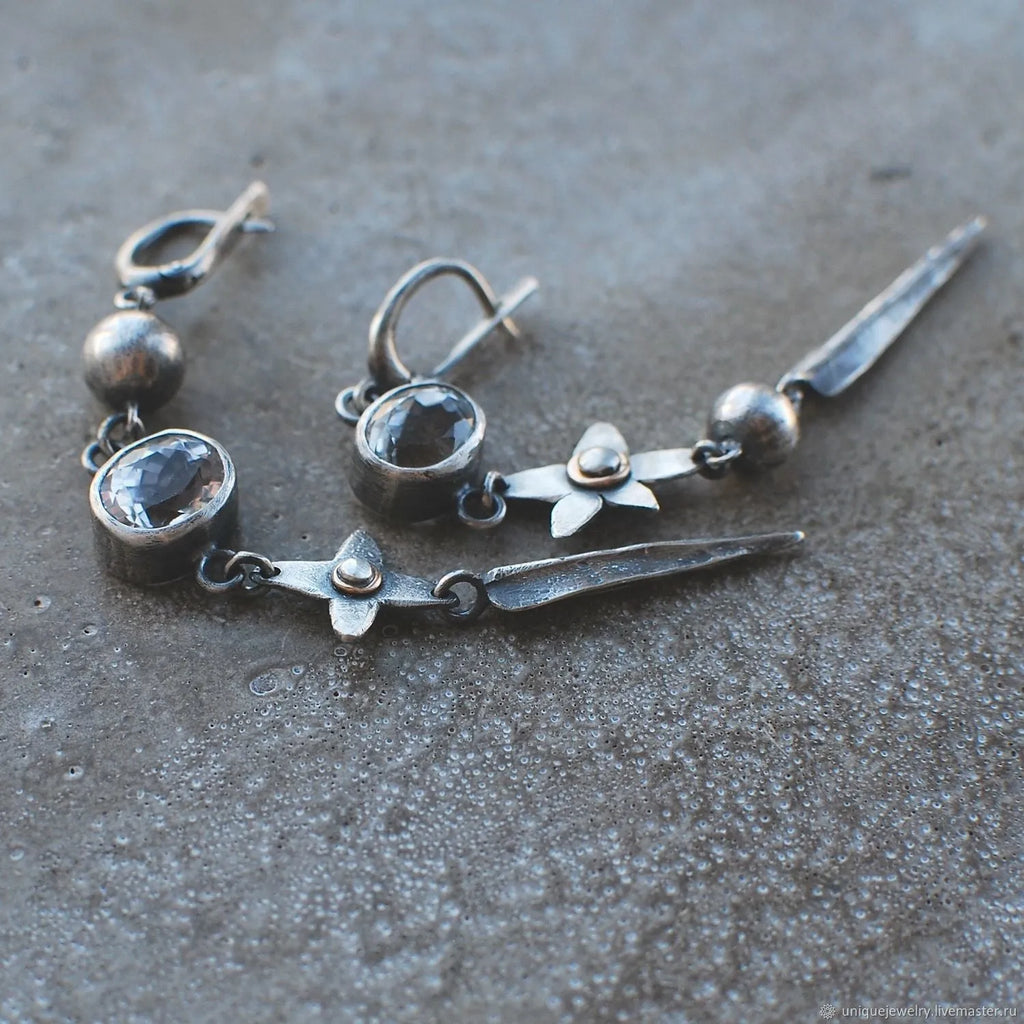 Geometric long pendant earrings with antique silver plating and rhinestone details on an XINGX design.