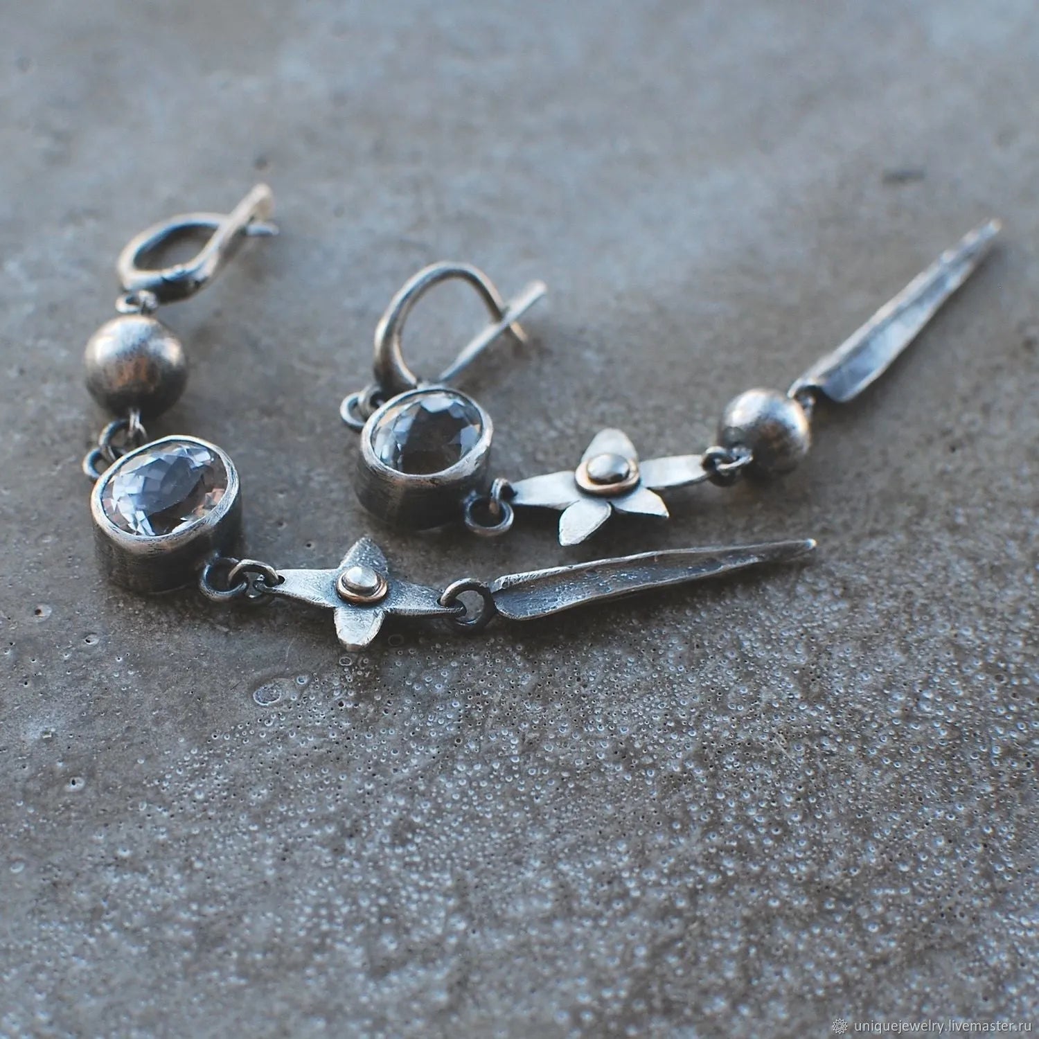Geometric long pendant earrings with antique silver plating and rhinestone details on an XINGX design.