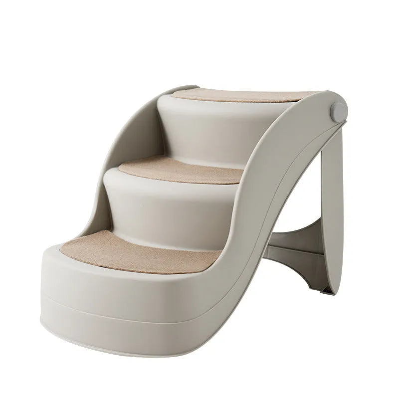 Foldable grey pet stairs with non-slip mats placed next to a sofa for dog or cat use