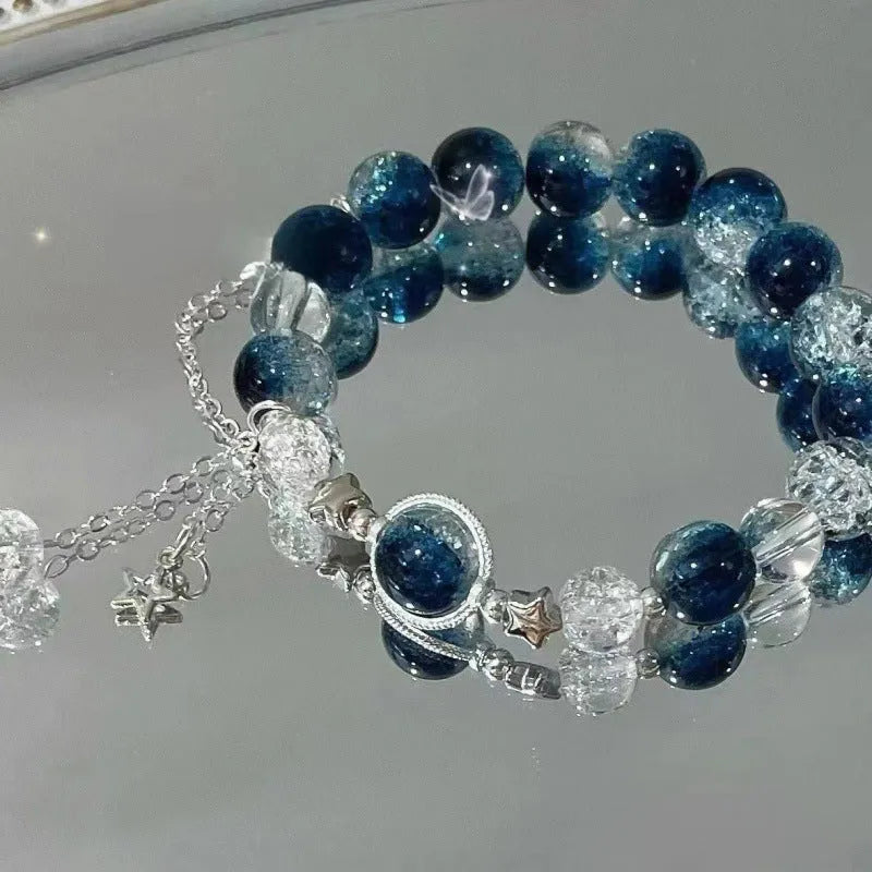 A Chinese style glass bracelet with bamboo leaf and bead designs on a wrist.