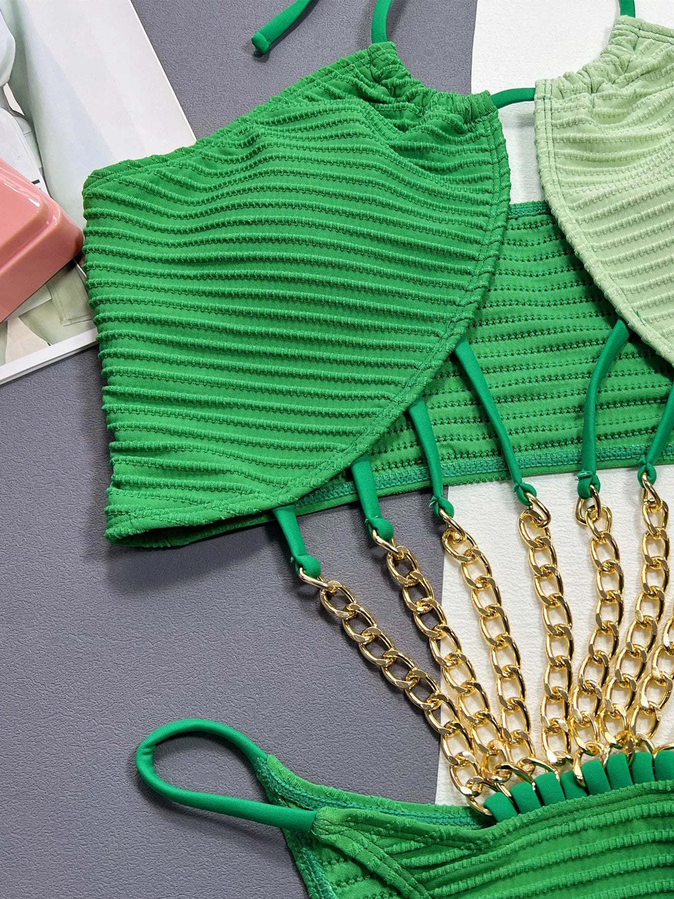 Green women's one-piece swimsuit with a hollow open back design on a mannequin.