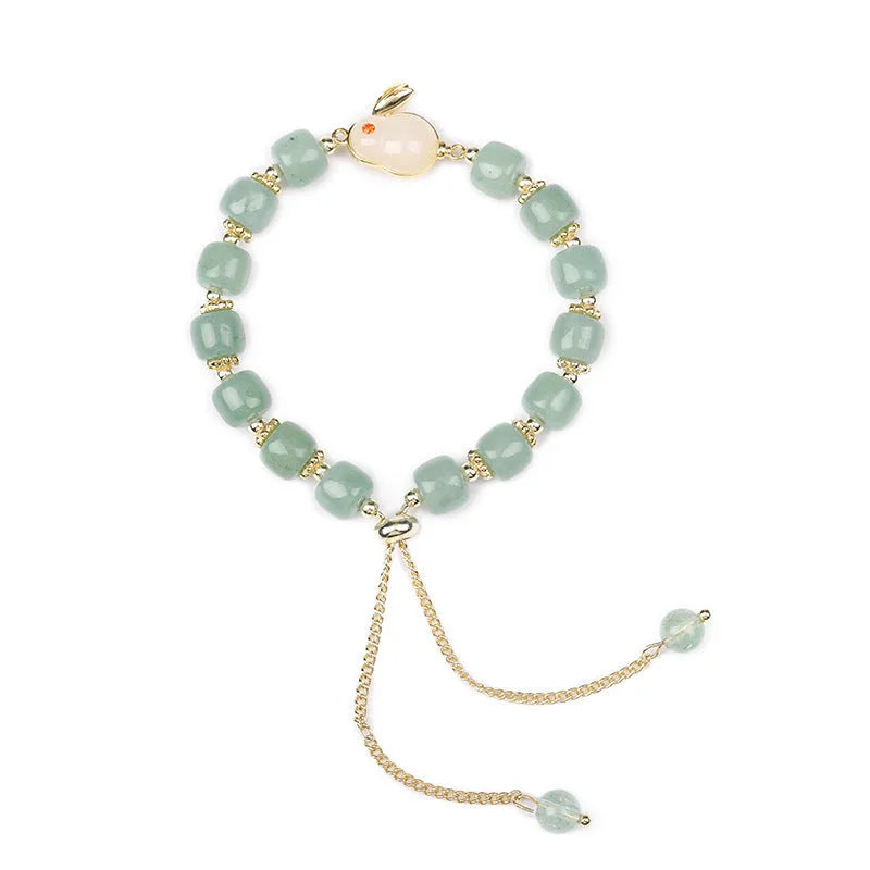 Women's rabbit charm bracelet with green aventurine stones and silver and gold plated metal links.