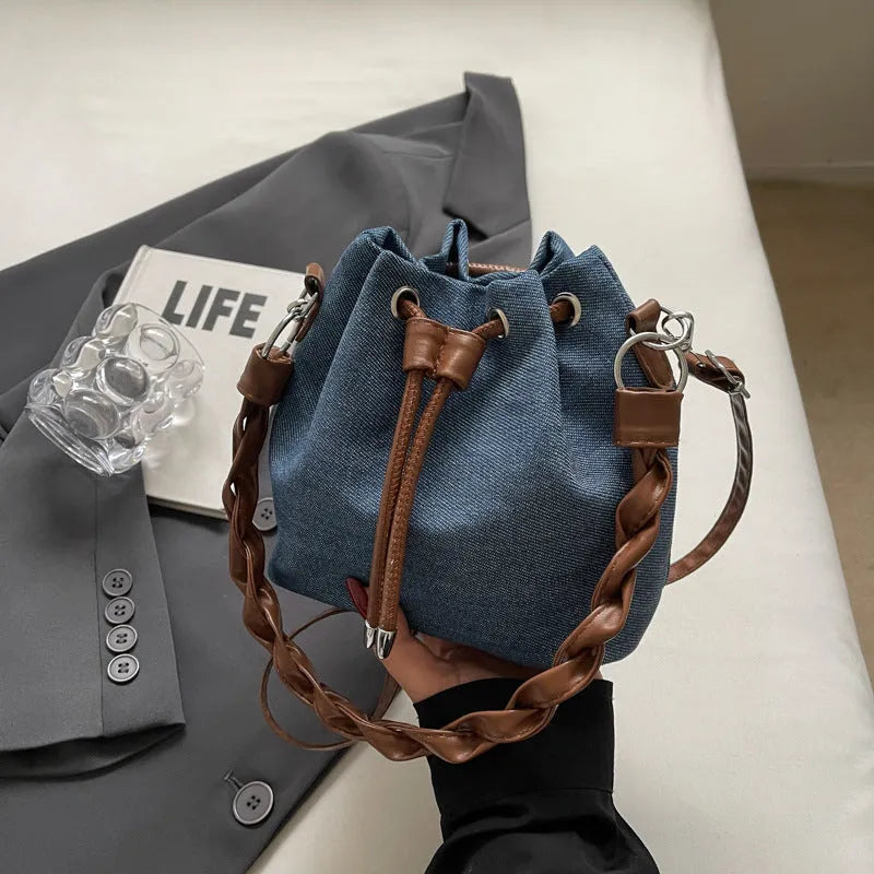 Blue synthetic leather cross-body bucket bag with adjustable strap and optional hanging drop decoration