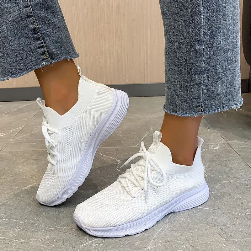 Women's low-top running shoes in creamy white with Flyknit upper and lace-up closure