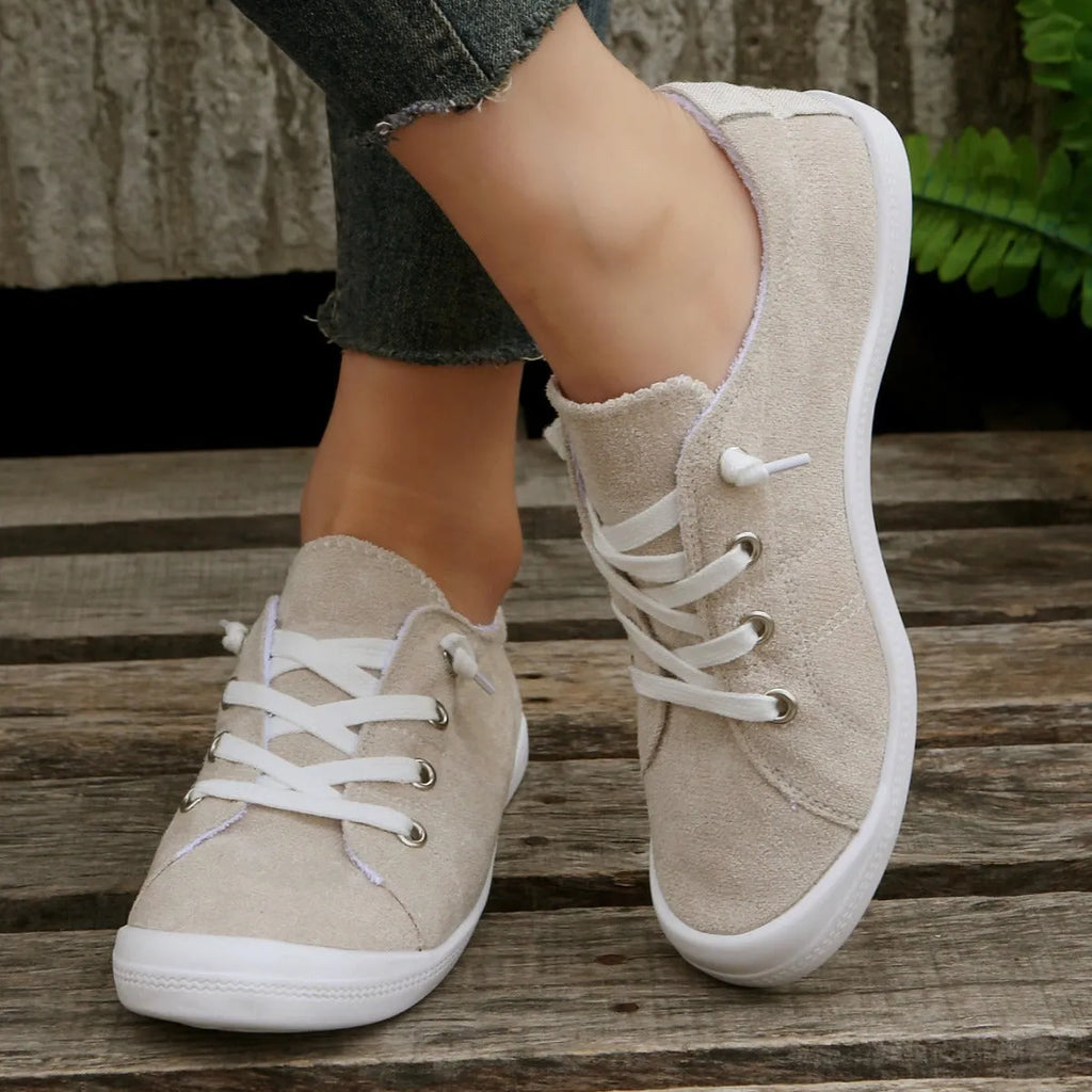 Women's low-top creamy white fabric sneakers with a wear-resistant rubber sole on a neutral background.