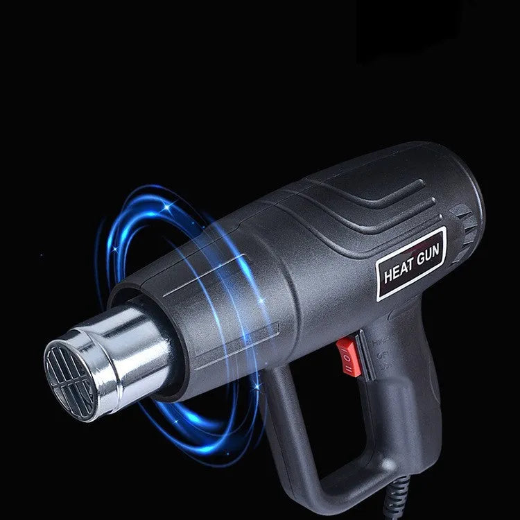 Black industrial hot air gun with a two-speed switch and grid-pattern nozzle on a workbench.