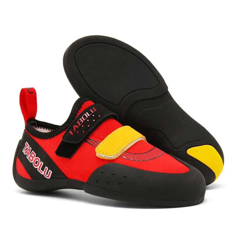 Black beginner rock climbing shoes with Velcro straps and a coloured accent on a rubber sole.