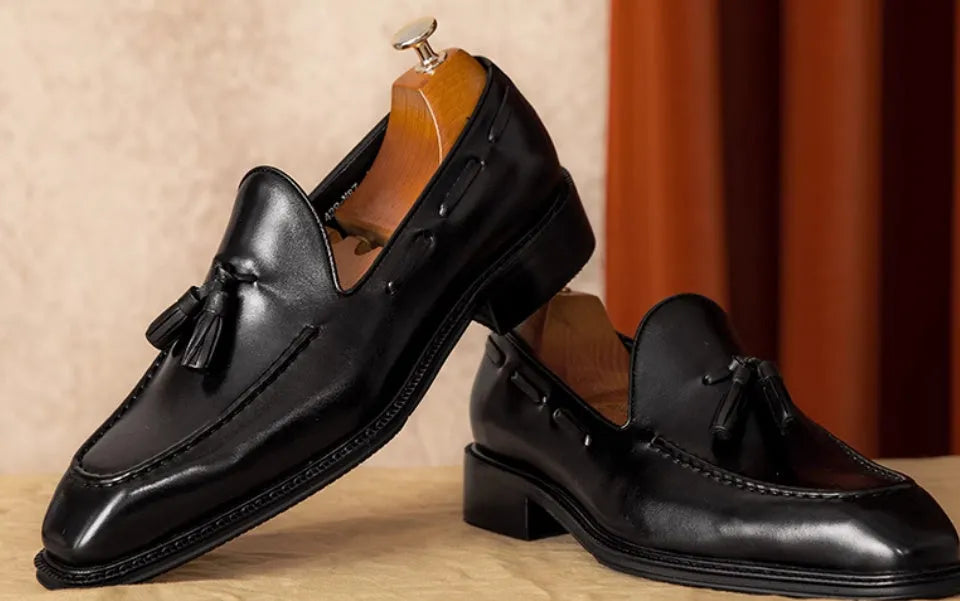 Men's black genuine leather loafers with fringed detail, rubber sole, and slip-on design