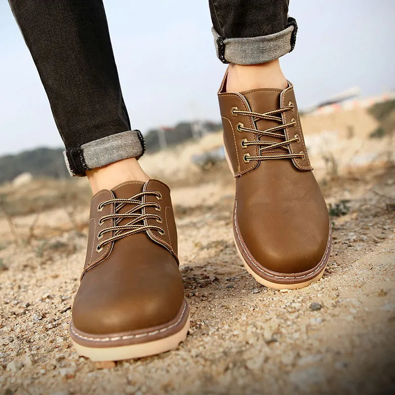 Men's black waterproof mid-top leather boots with flat rubber soles