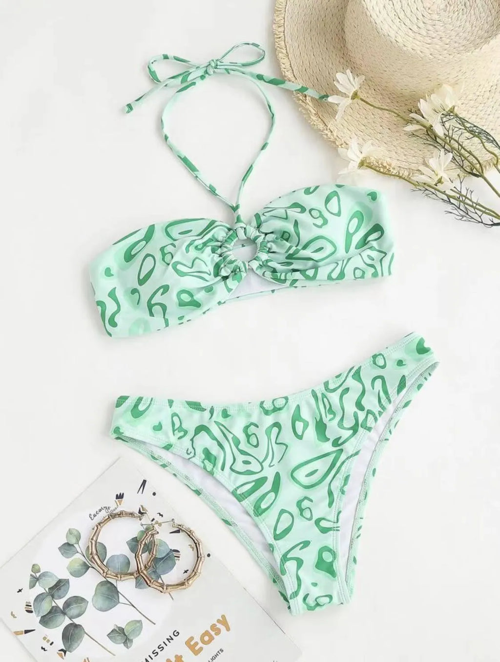 Women's blue floral bandeau bikini swimsuit with split design on beach background