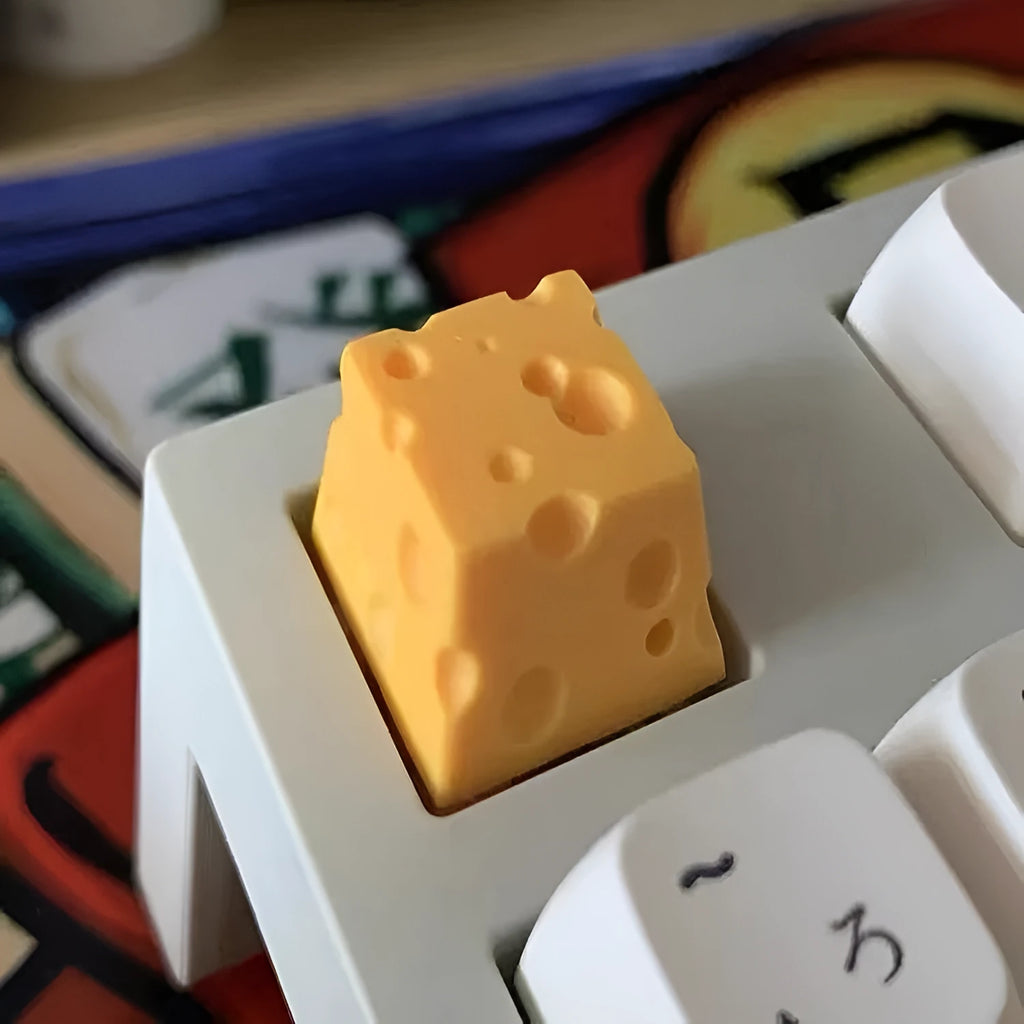 Close-up of a yellow solid resin cheese-themed keycap for mechanical keyboards.