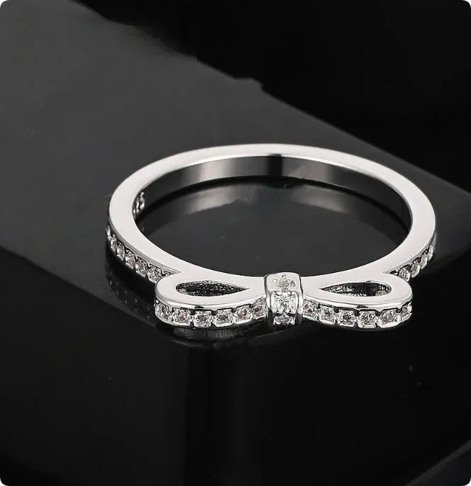 Silver bow ring with zircon crystal and rhinestone detailing on finger