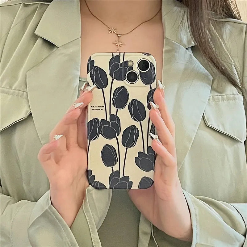 Black silicone iPhone case with a large tulip flower design on the back.