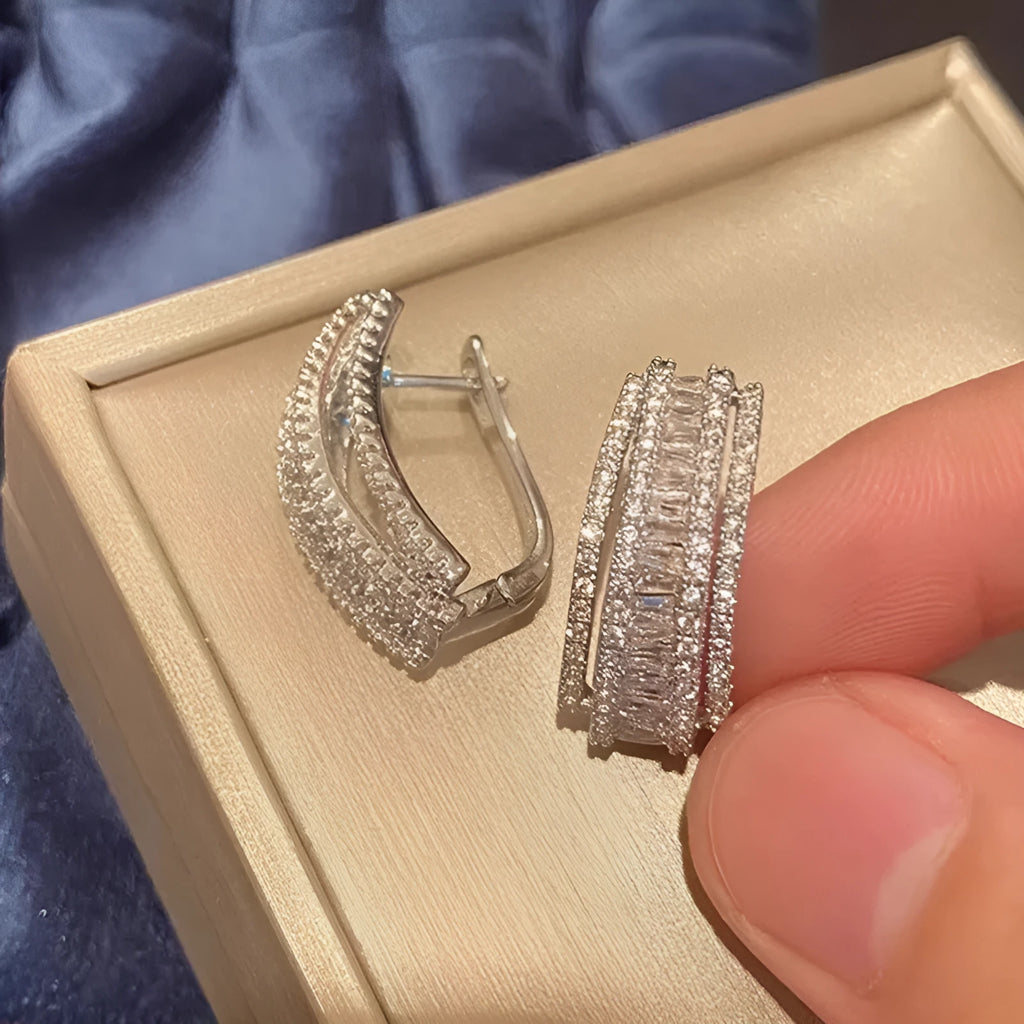 A pair of women's geometric stud earrings with inlaid zircon detail in a white gold colour.