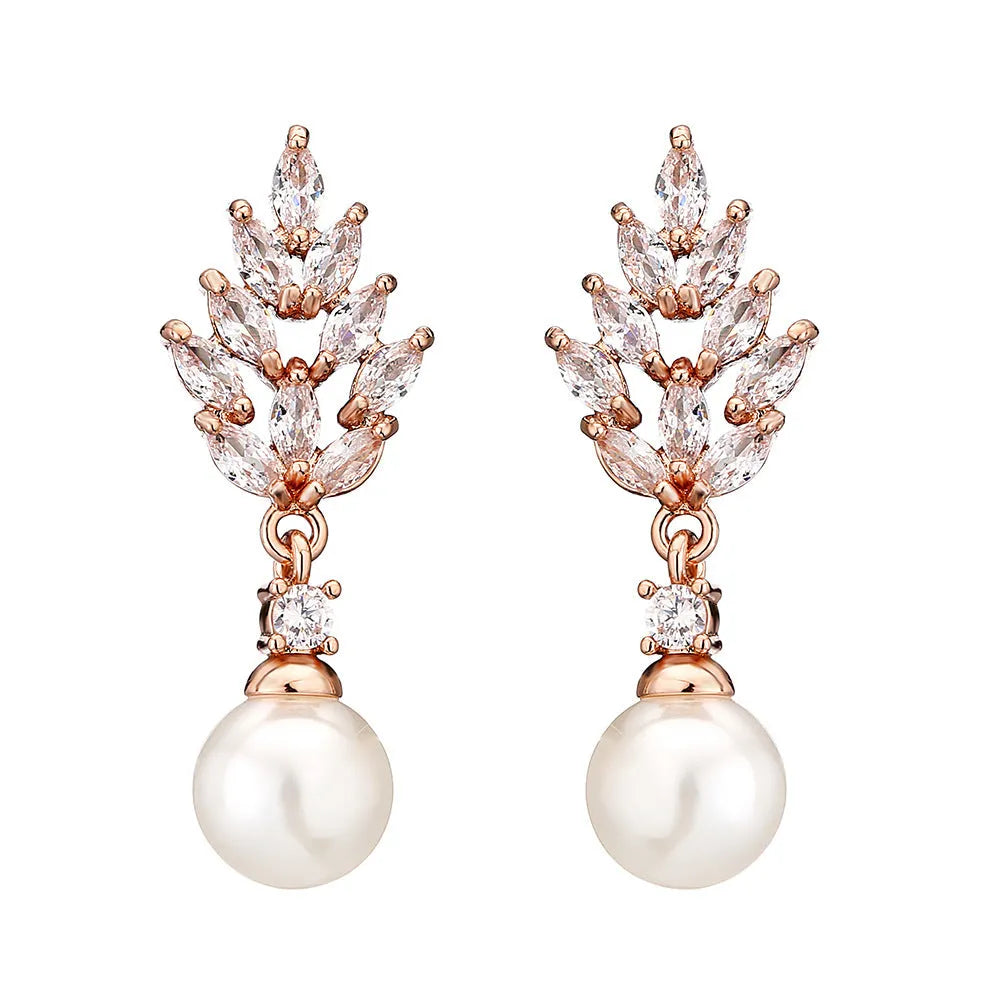Geometric flower shaped earrings with micro inlaid zircon stones and pearl accents on a gold plated background.