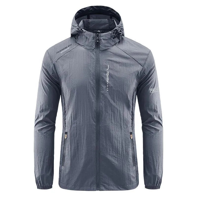 Man wearing a lightweight grey hooded nylon summer jacket outdoors.