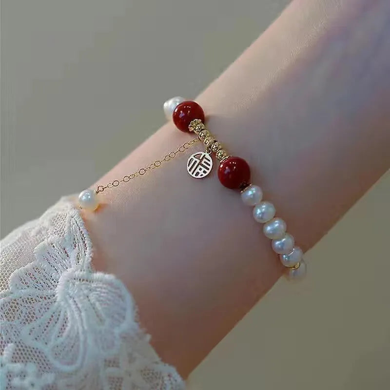 A Chinese style glass bracelet with bamboo leaf and bead designs on a wrist.