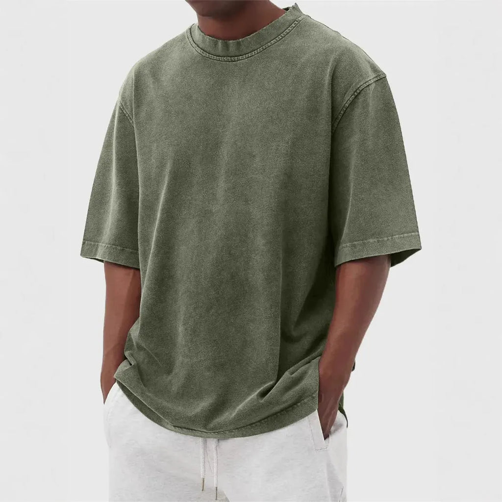 Man wearing a loose-fit stone washed solid colour t-shirt in a casual setting.
