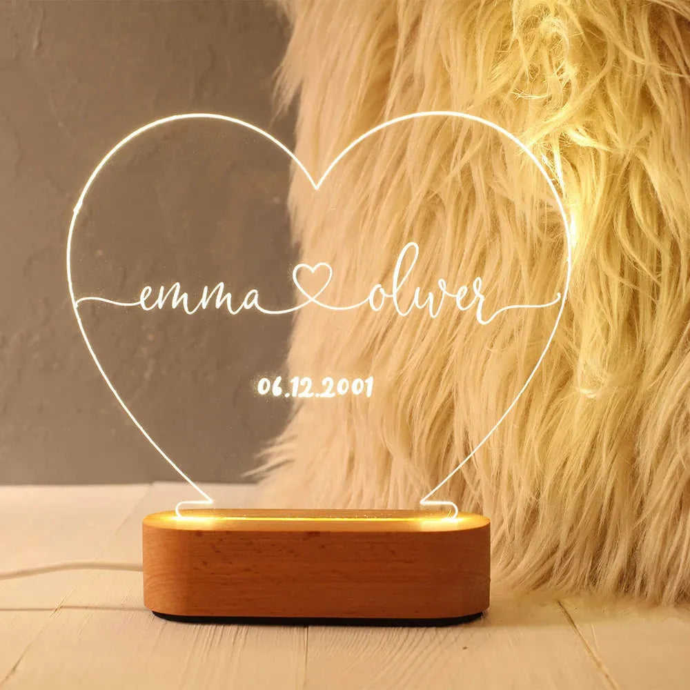 Custom clear acrylic night light with engraved names, lit by an LED base.