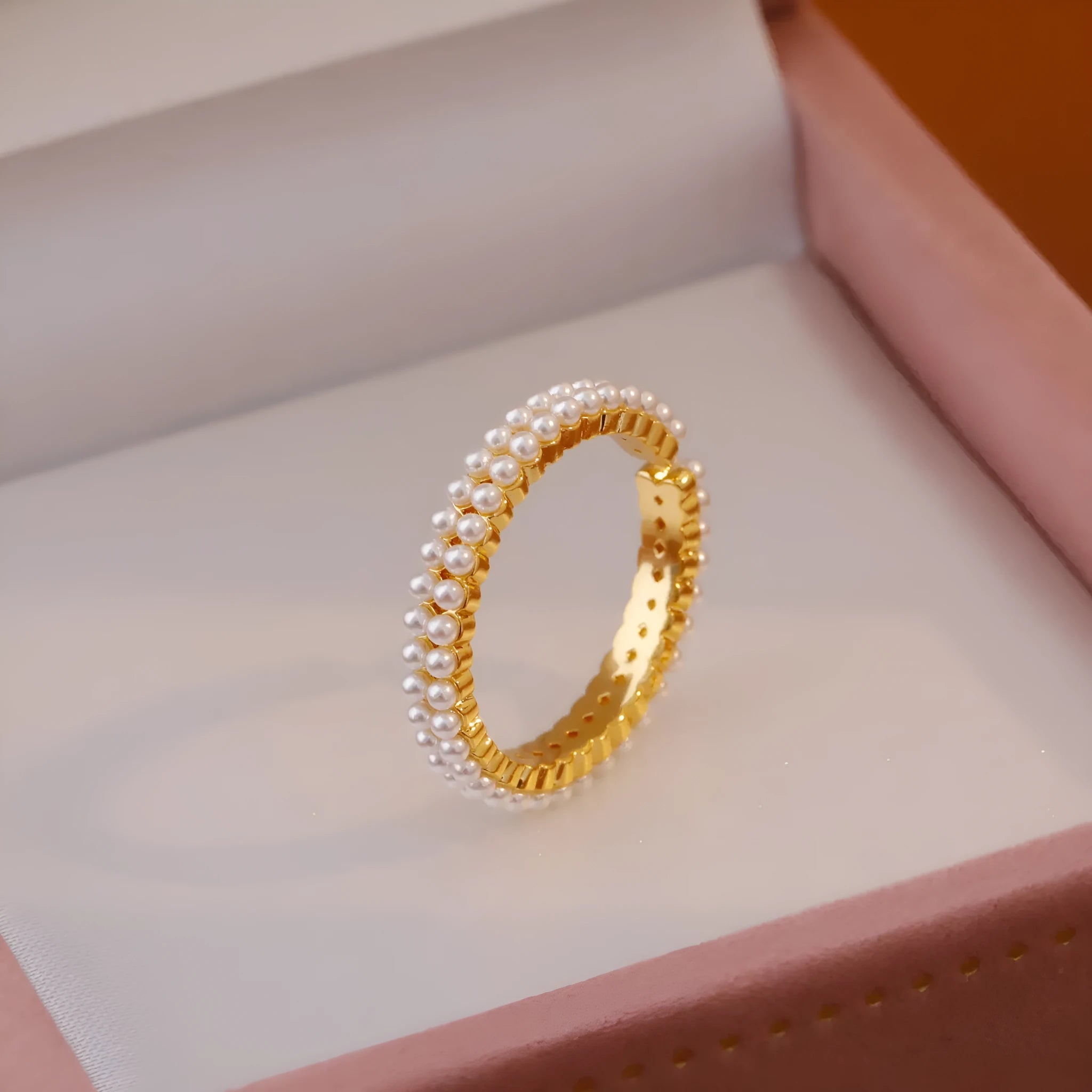 Gold coloured women's ring with open mouth design and round pearl elements on copper electroplated construction