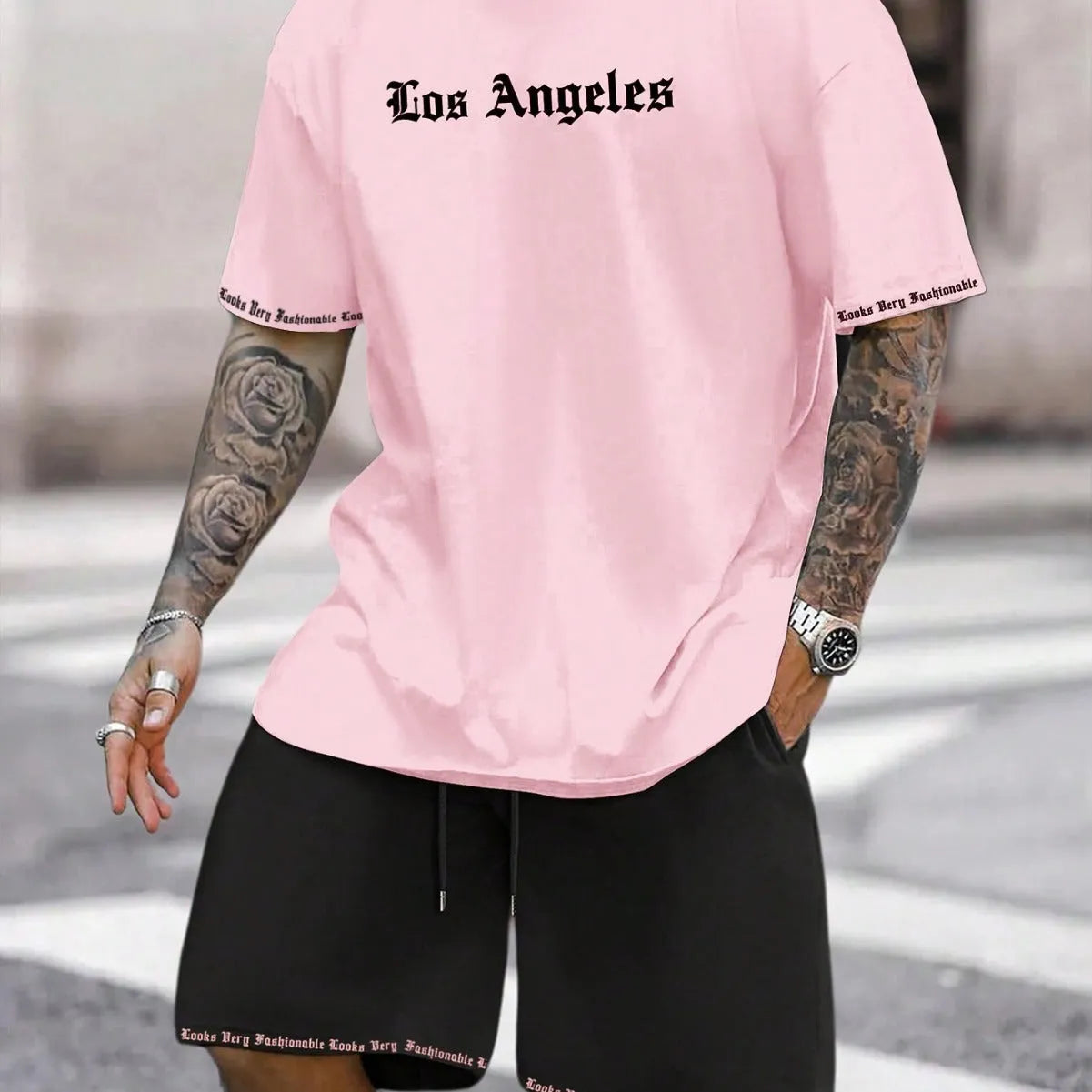 Man wearing a grey short-sleeve top and matching shorts from a sports co-ord set.