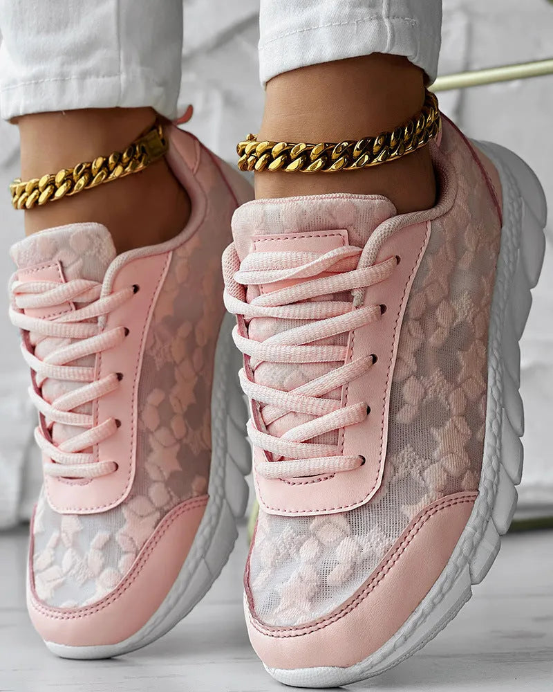 Women's white canvas sports shoes with flat heel and round toe design on neutral background