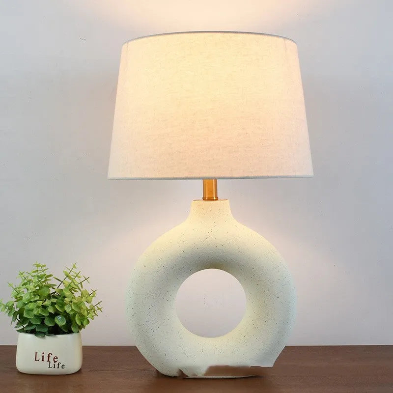 Small white Japanese style Feng Pottery Pot table lamp with ceramic base and fabric shade on a desk.